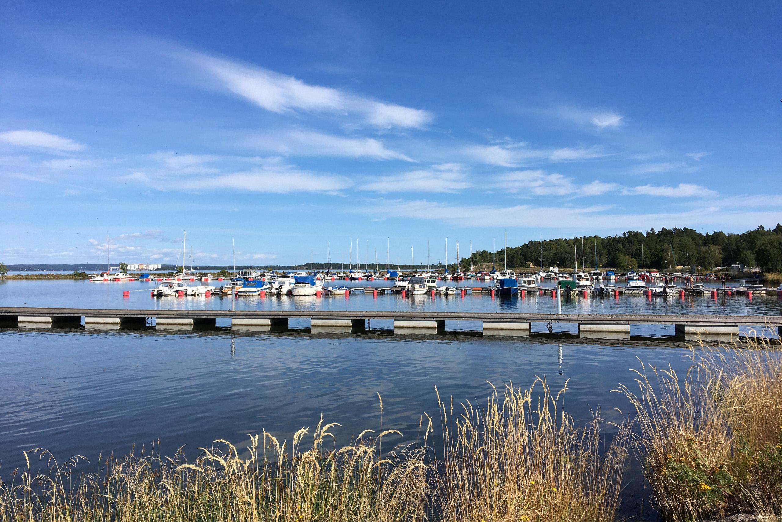 Lindö med småbåtshamn med båtar och bryggor en solig sommardag.