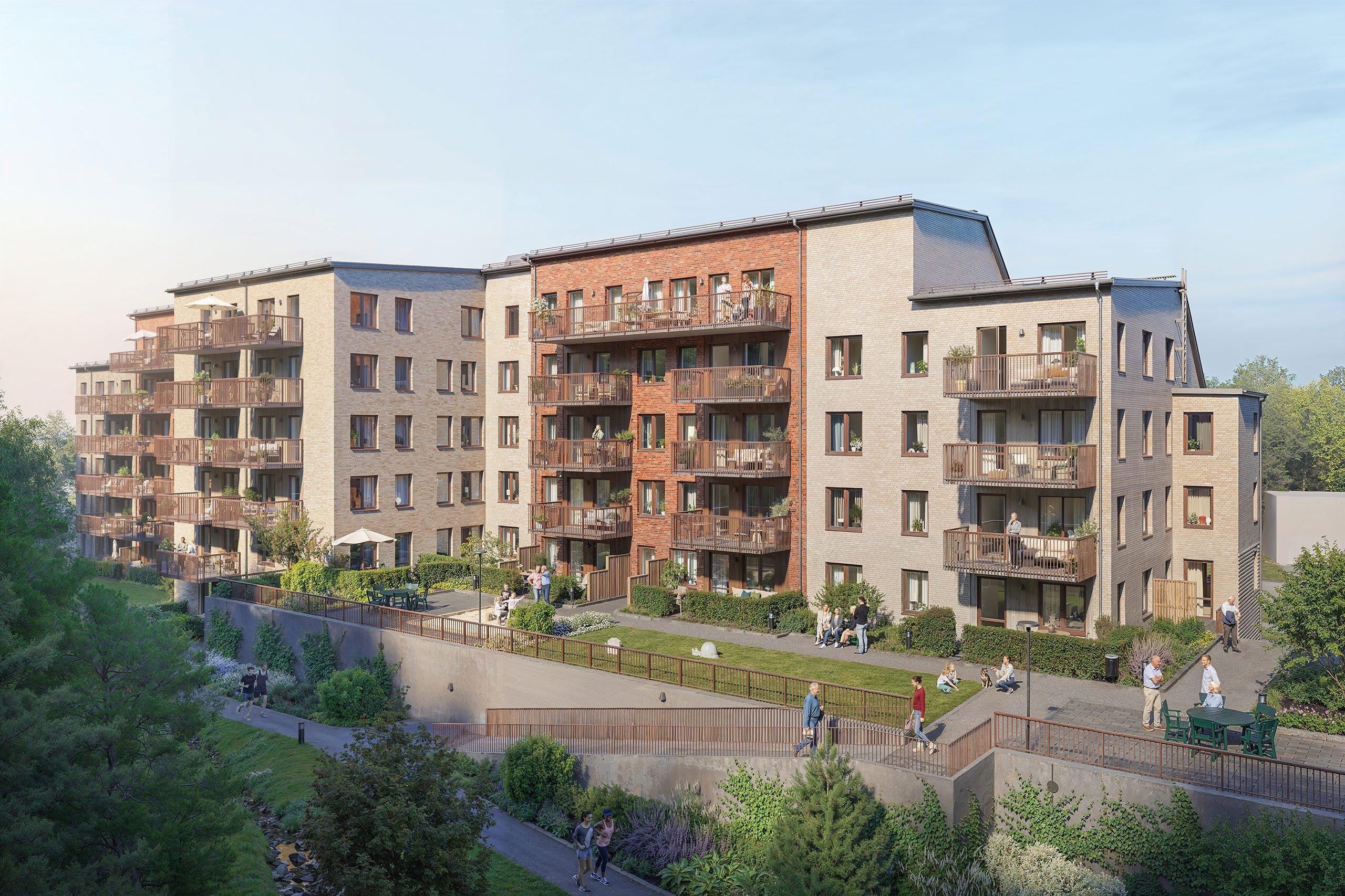 Flerbostadshus med balkonger vid skogsbrynet.