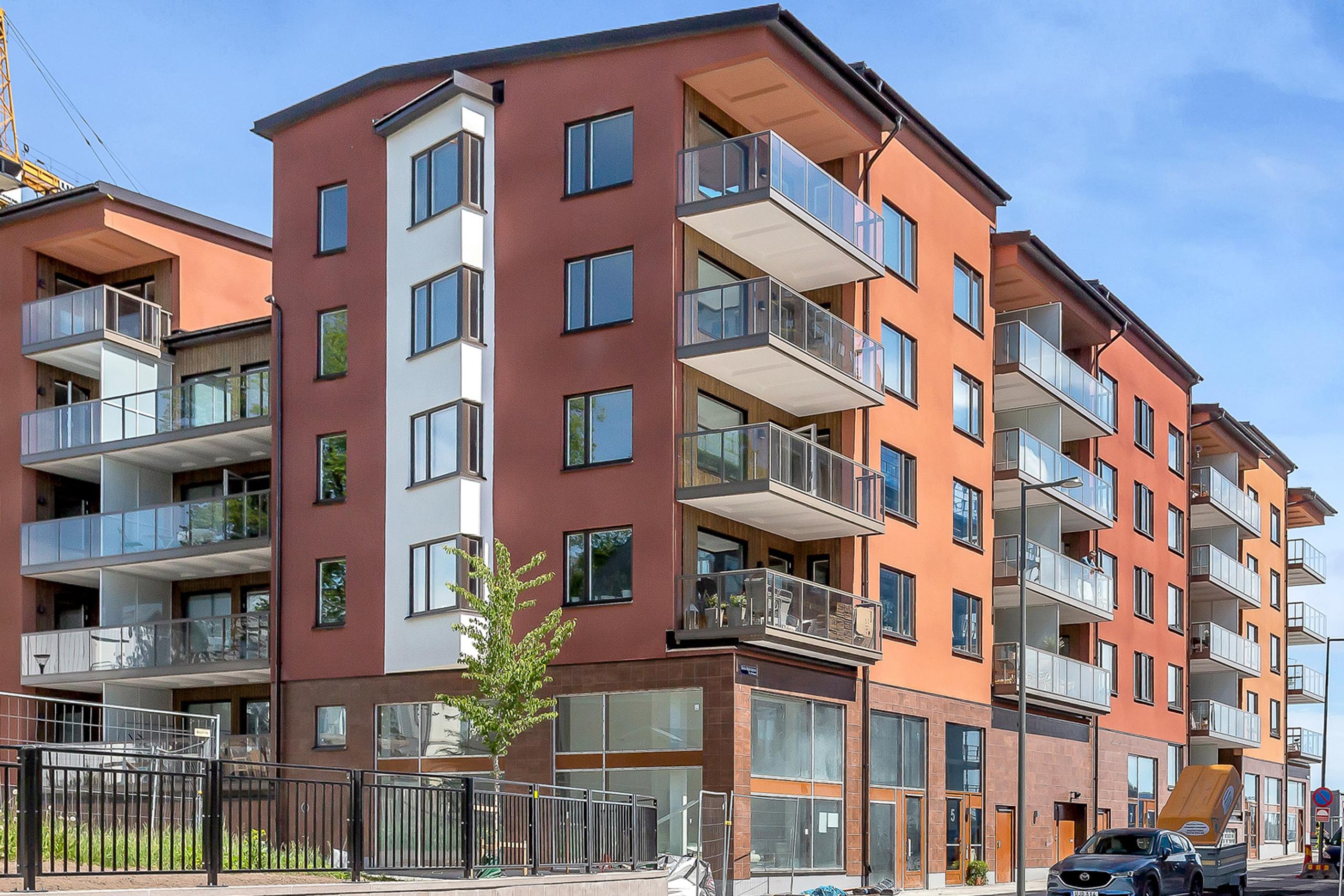 Byggnaden färgsätts i mustiga bruna nyanser och fasaden kläs med puts och trä.