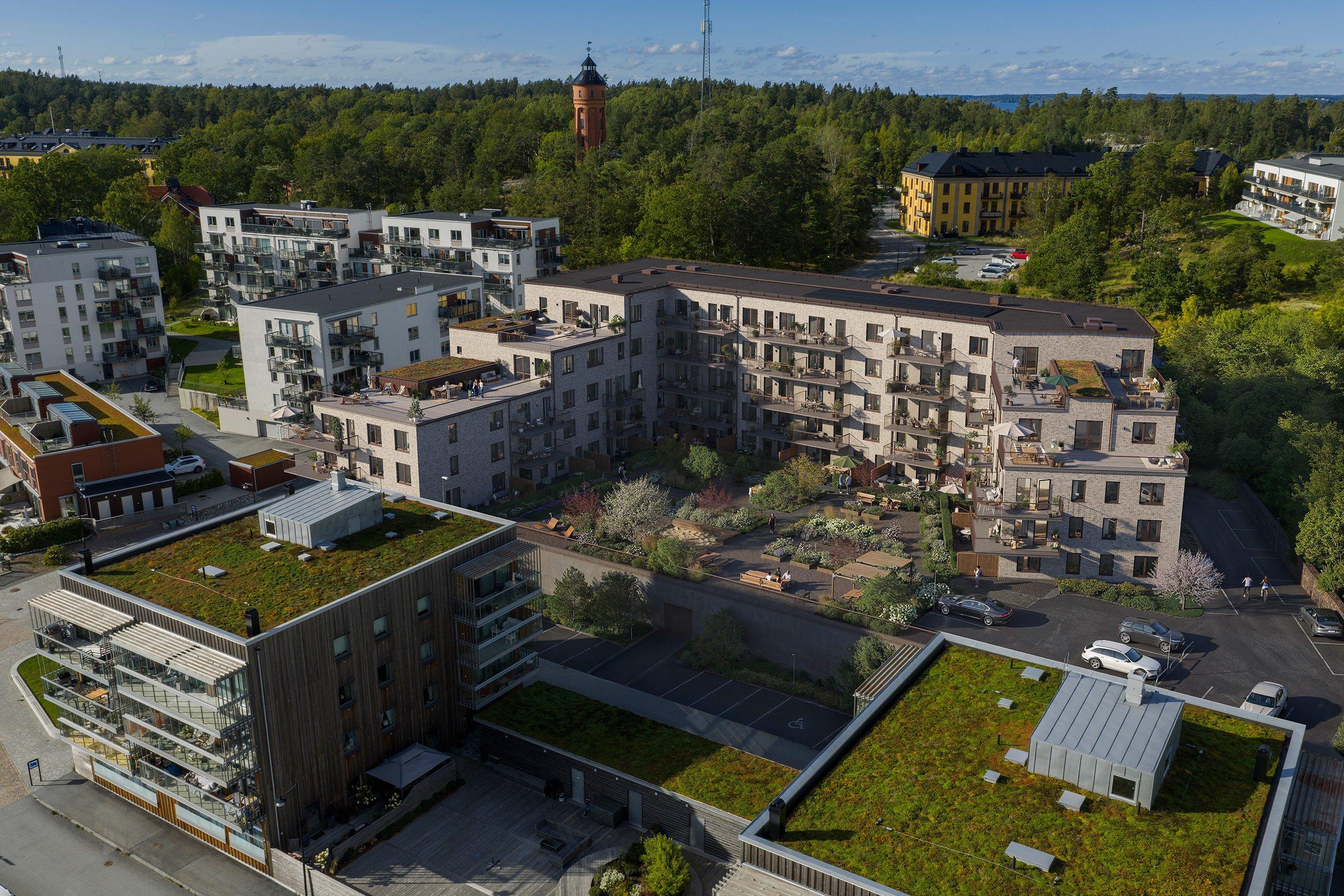U-format bostadskvarter runt gård med många planteringar.
