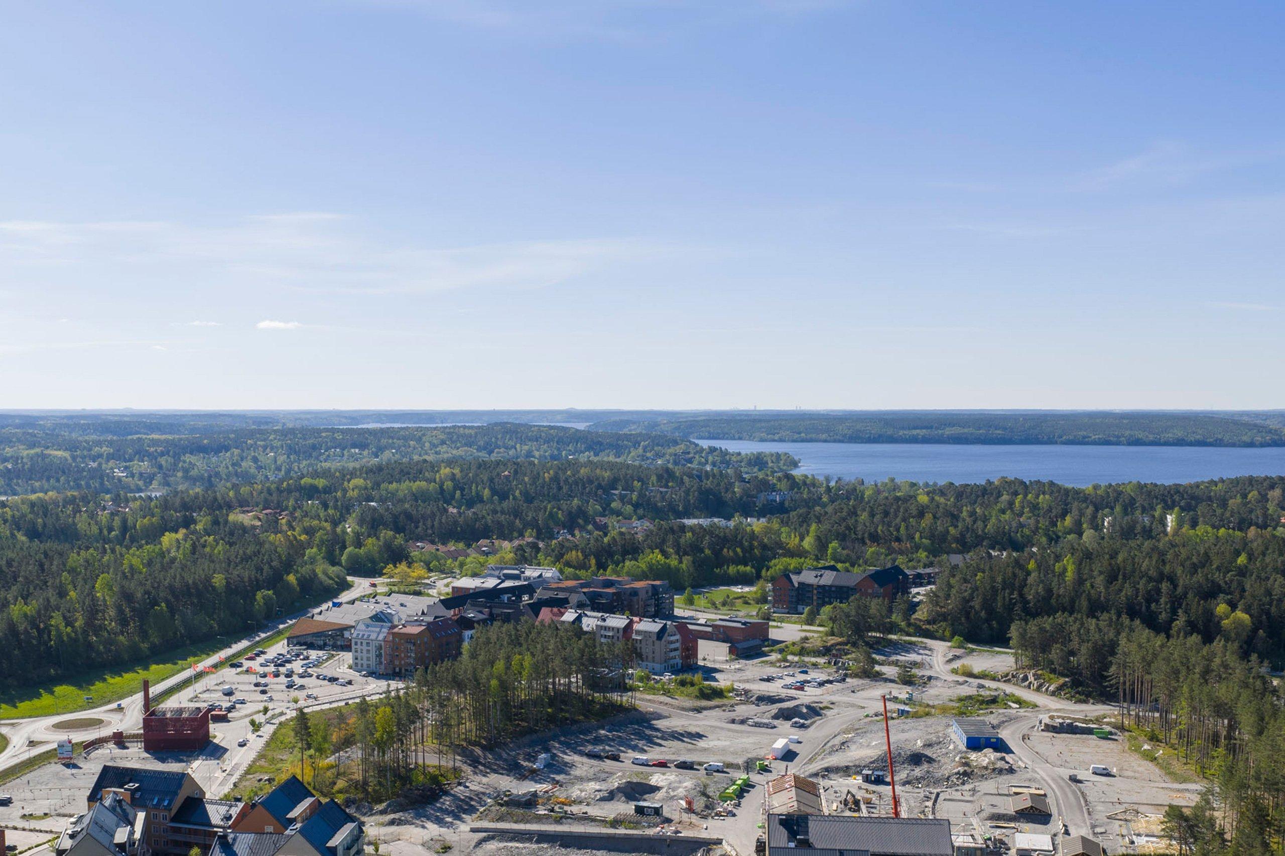 Vy över Sigtuna stadsängar, Sigtuna med lummig grönska och Mälaren.