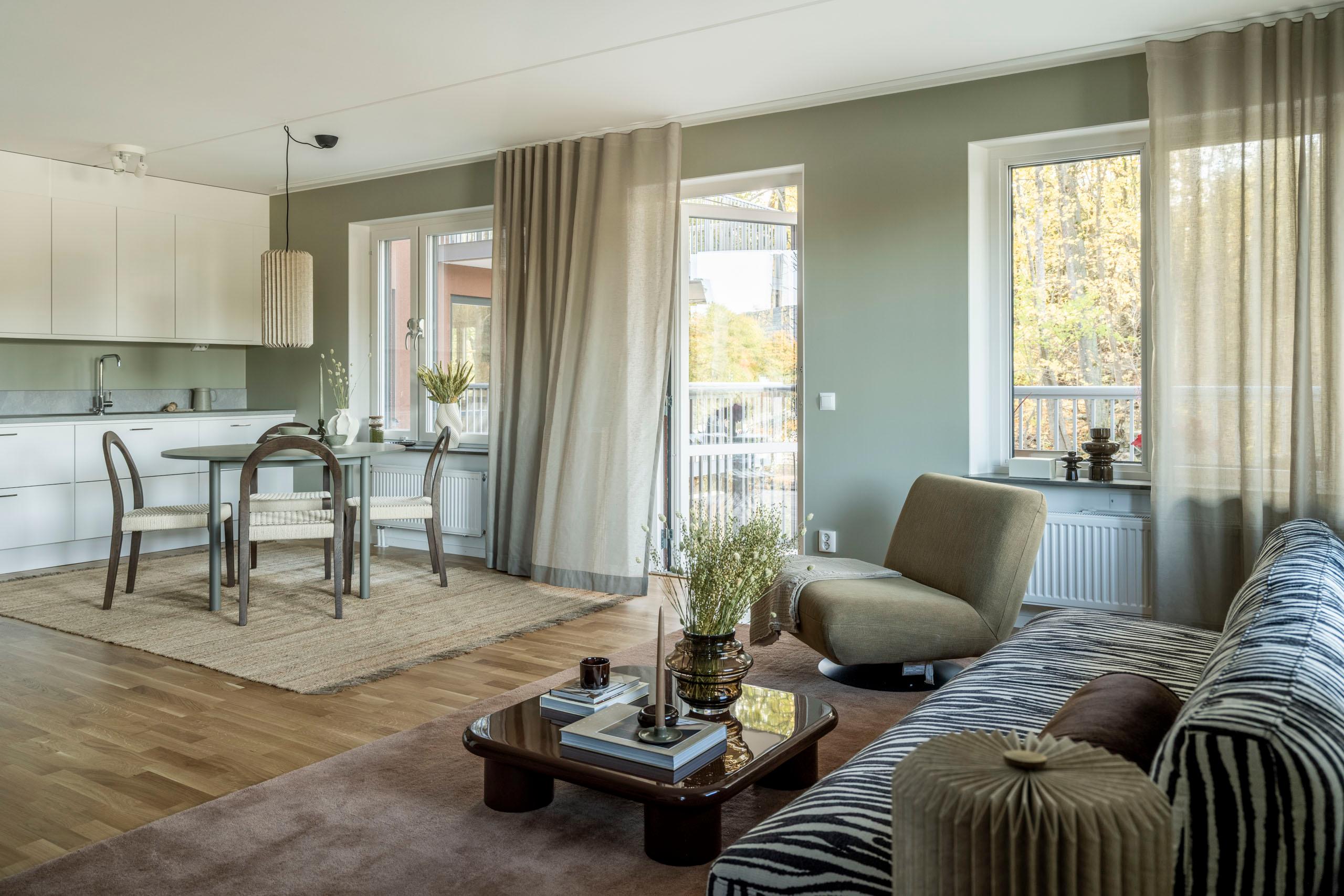 Modernt kök mot vardagsrum med öppen planlösning.