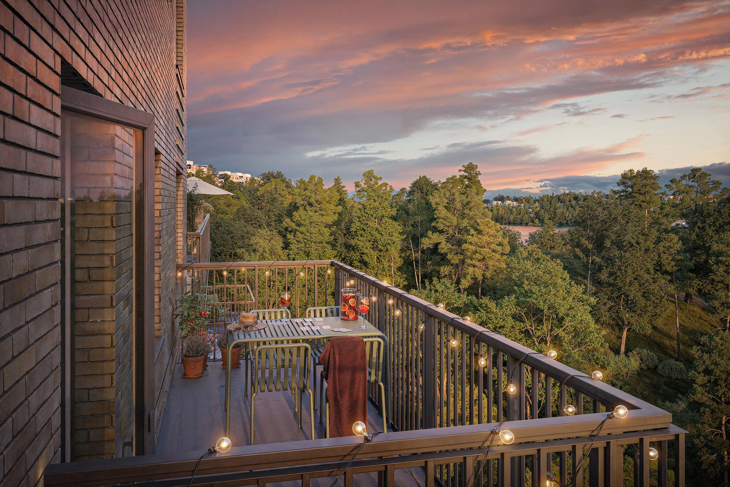 Modern balkong med utsikt över lummigt skogsparti.