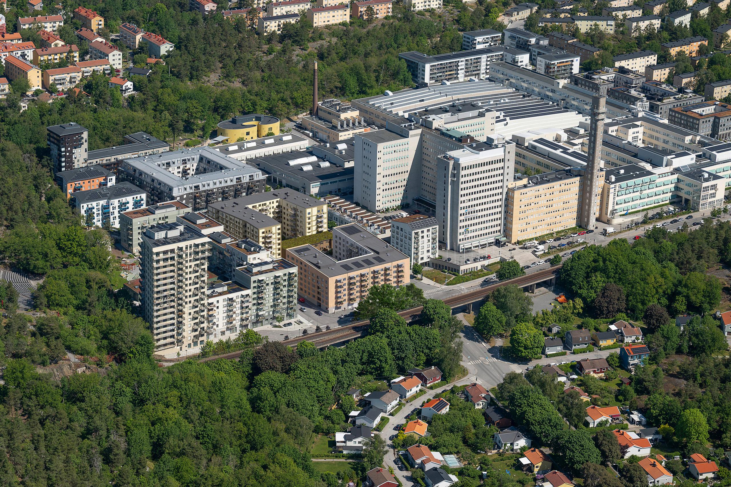 Flera bostadskvarter omgivna av lummigt skogsparti.