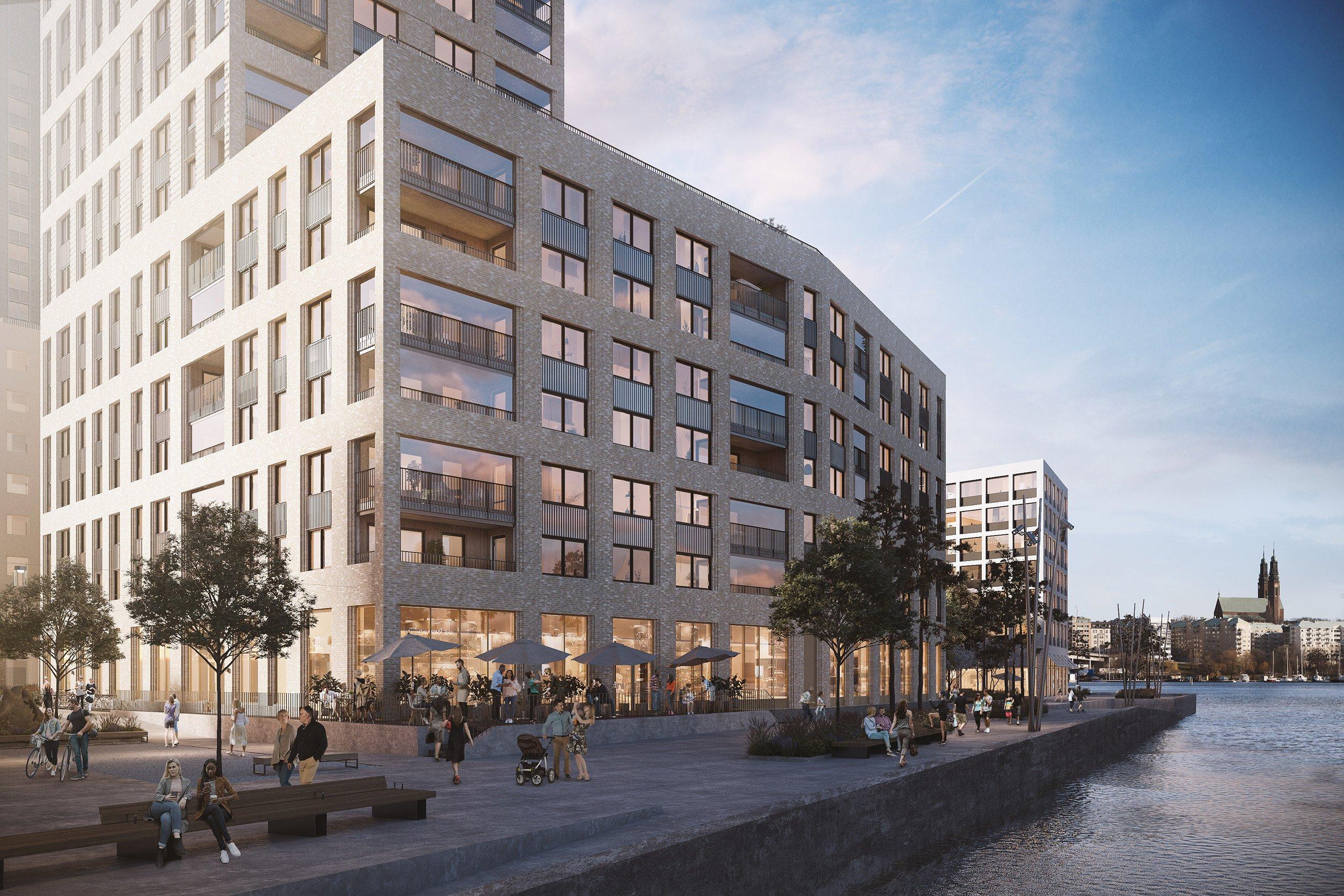 Husfasad mot vatten med kajpromenad framför.