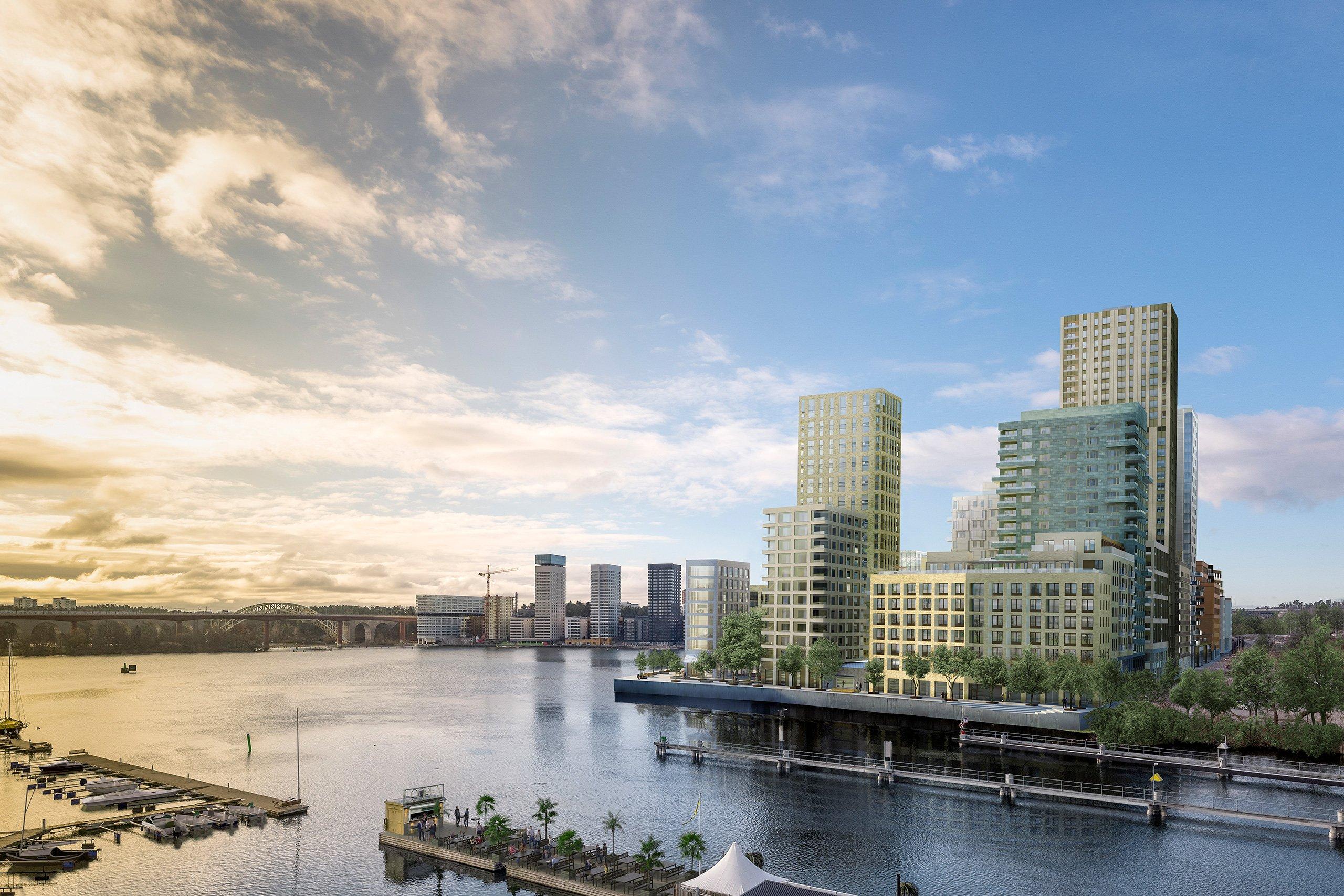 Flera höga hus med vatten och båtbryggor framför.