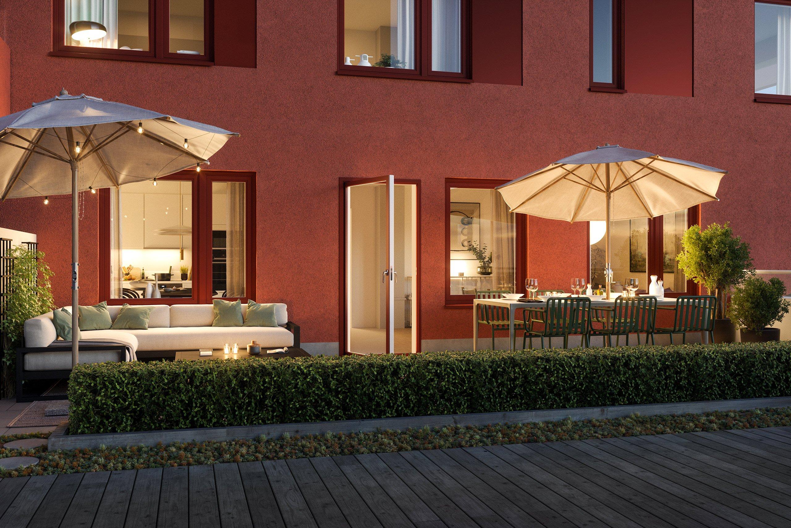 Uteplats med sittmöbler i kvällsbelysning.