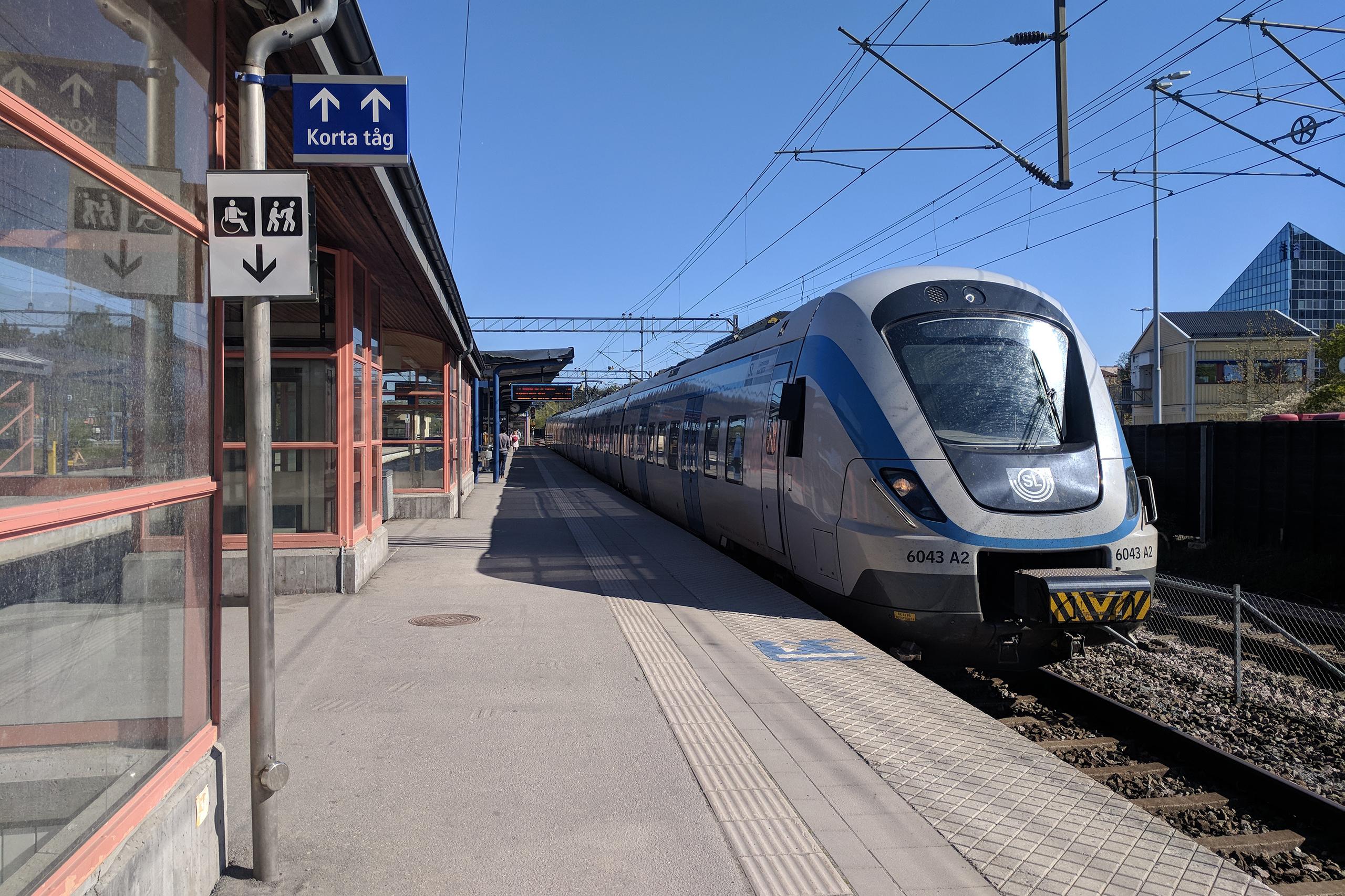 Pendeltågsstation med ett pendeltåg vid perrongen i Upplands Väsby.
