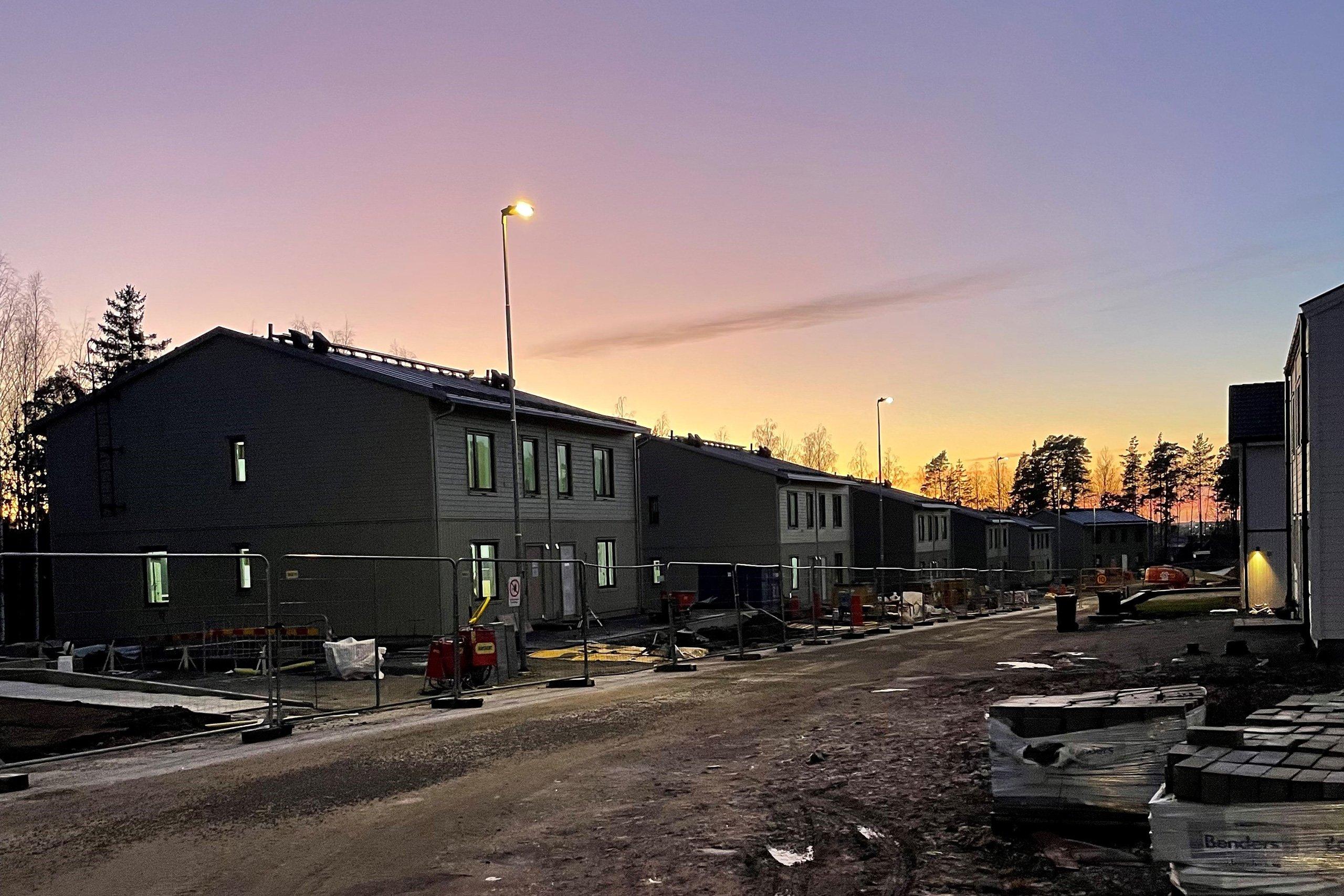 Kvartersgata med hus i skymningsljus under stomvisning i Skölstadalen.