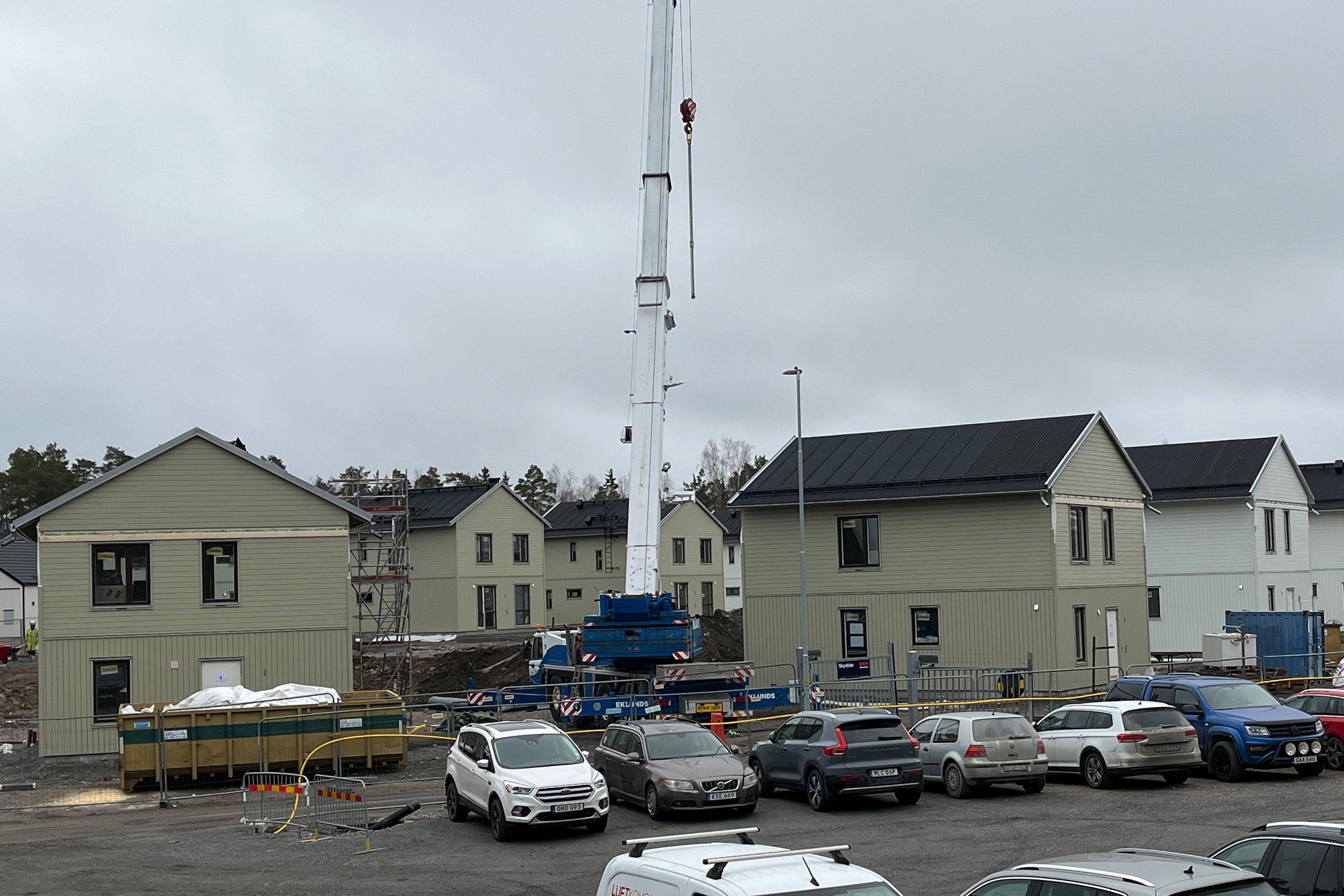 Taklagsfest och foto på husen i Skölstadalen i februari 2025, en byggkran i mitten av bilden.