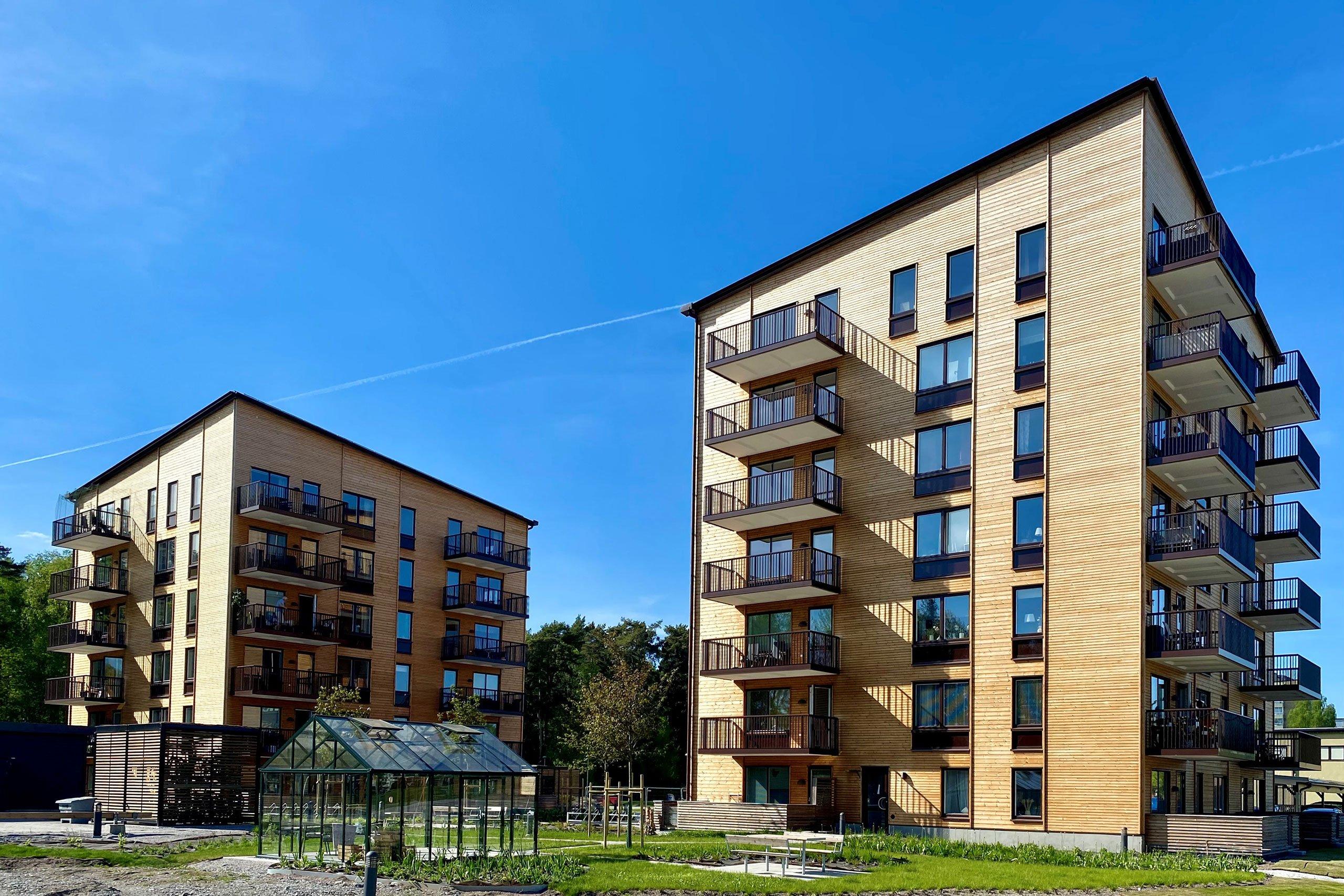 Foto på Skiljebo Ängs två punkthus med ljusa träfasader.