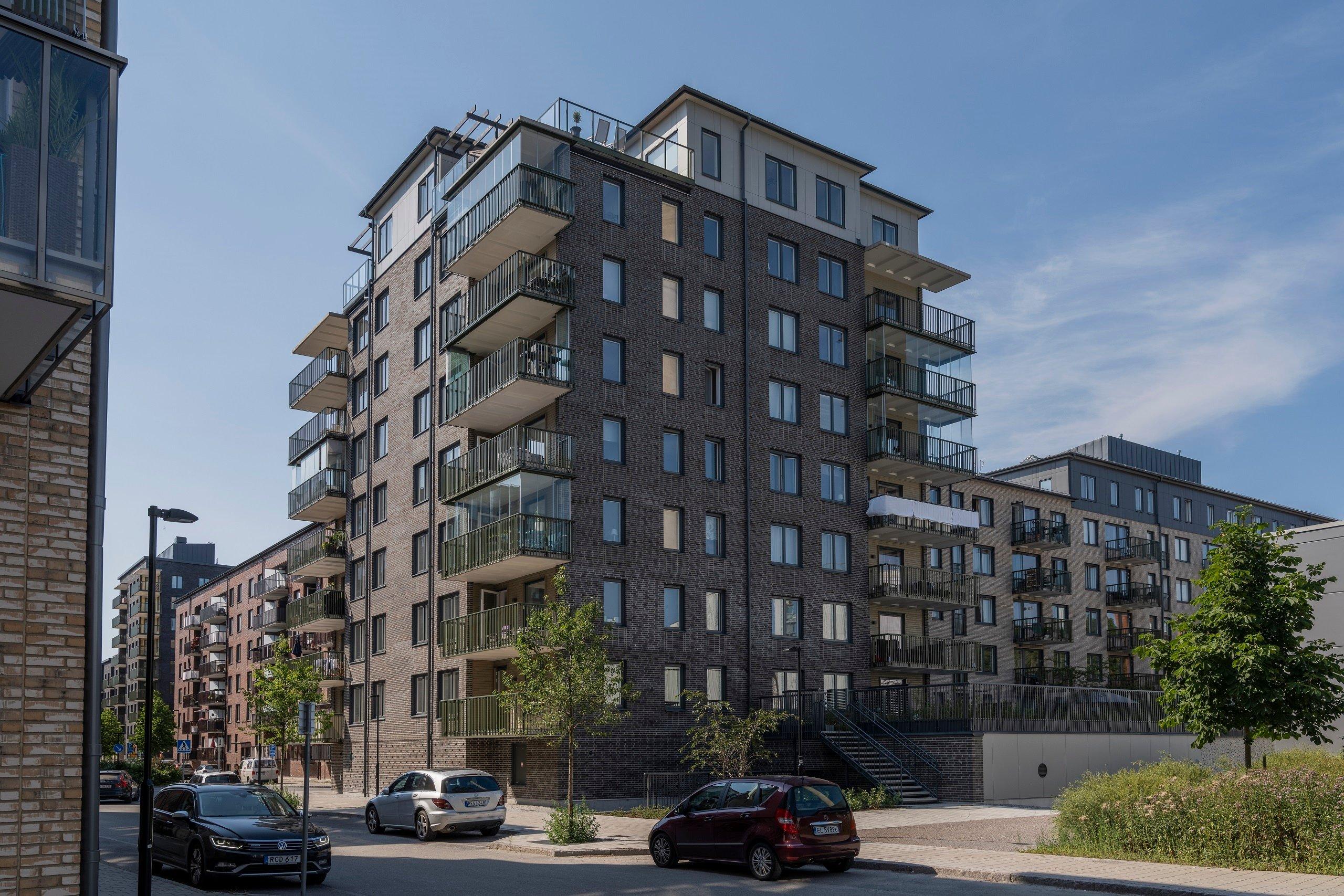 Fasad med balkonger och innergård upphöjd från gatan.