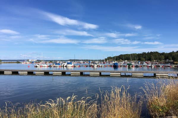Lindö med småbåtshamn med båtar och bryggor en solig sommardag.