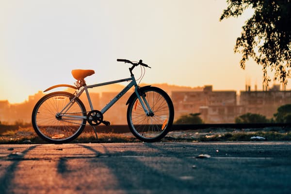 Solnedgång med en parkerad cykel i silhuett.