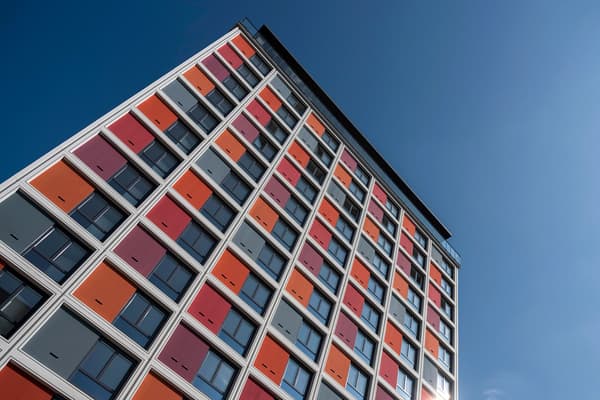 Modern husfasad med starka kulörer mot blå himmel.