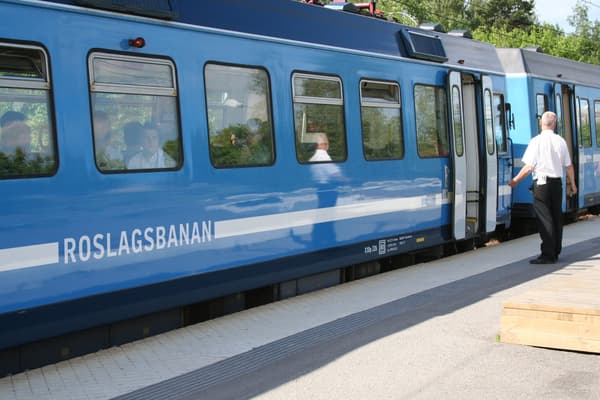 Roslagsbanan med passagerare står still vid perrongen.