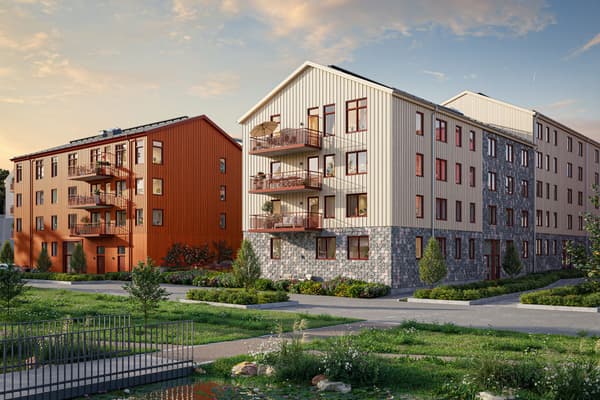 Bonicas flerbostadshus i beigevit och röda färger med dagvattenstråket precis utanför porten.