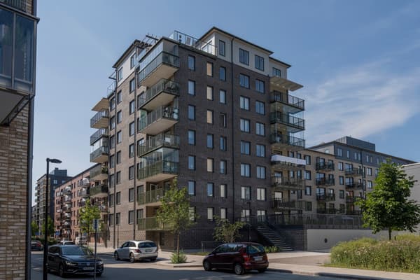 Fasad med balkonger och innergård upphöjd från gatan.