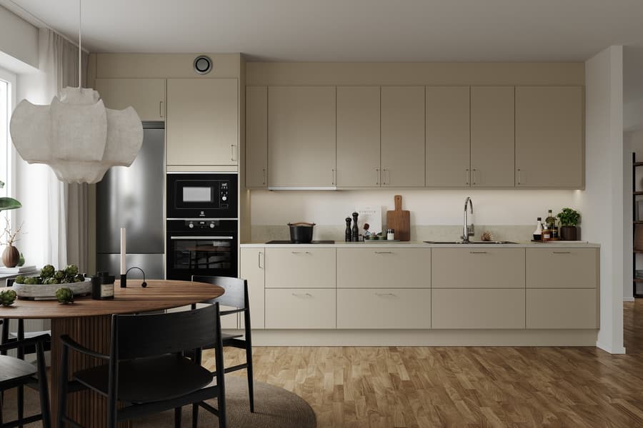 JM Original kök med ljusa köksluckor, rostfria vitvaror samt ugn och mikro i högskåp.