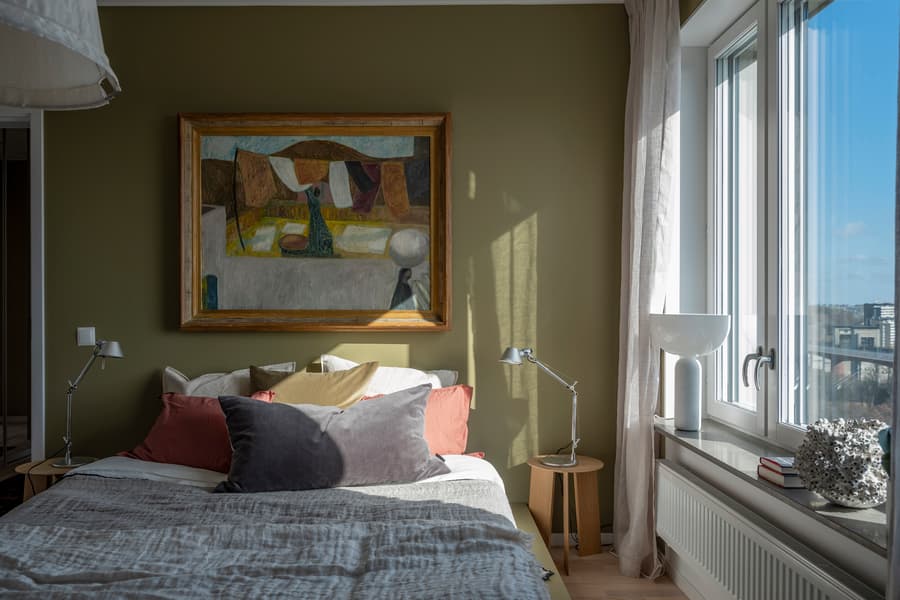 Ett soligt sovrum med färgglada kuddar i en JM-visningslägenhet 