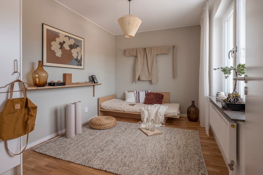 Sovrumsinredning. Beige väggfärg och inredningsdetaljer i jordfärger.