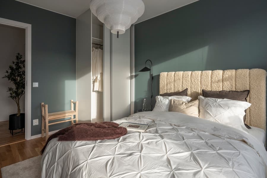 Sovrumsinredning. Grågröna väggar och inredningsdetaljer i brunt och beige.