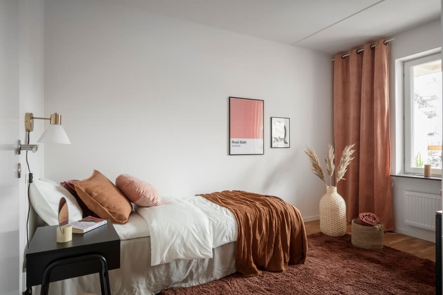 Sovrumsinredning. Vita väggar och detaljer i jordnära färger.