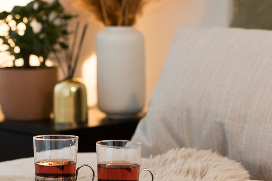 Sovrumsinredning. Levande ljus, belysning, säng och kuddar.